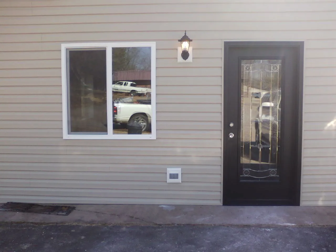 New siding, window and entry door on the side of an addition in Elberon