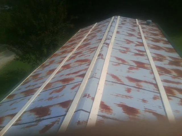 Rusted metal roof panels with new wood purlins before replacement — Storm Damage Roof Repair in Elberon by Roofing Brothers