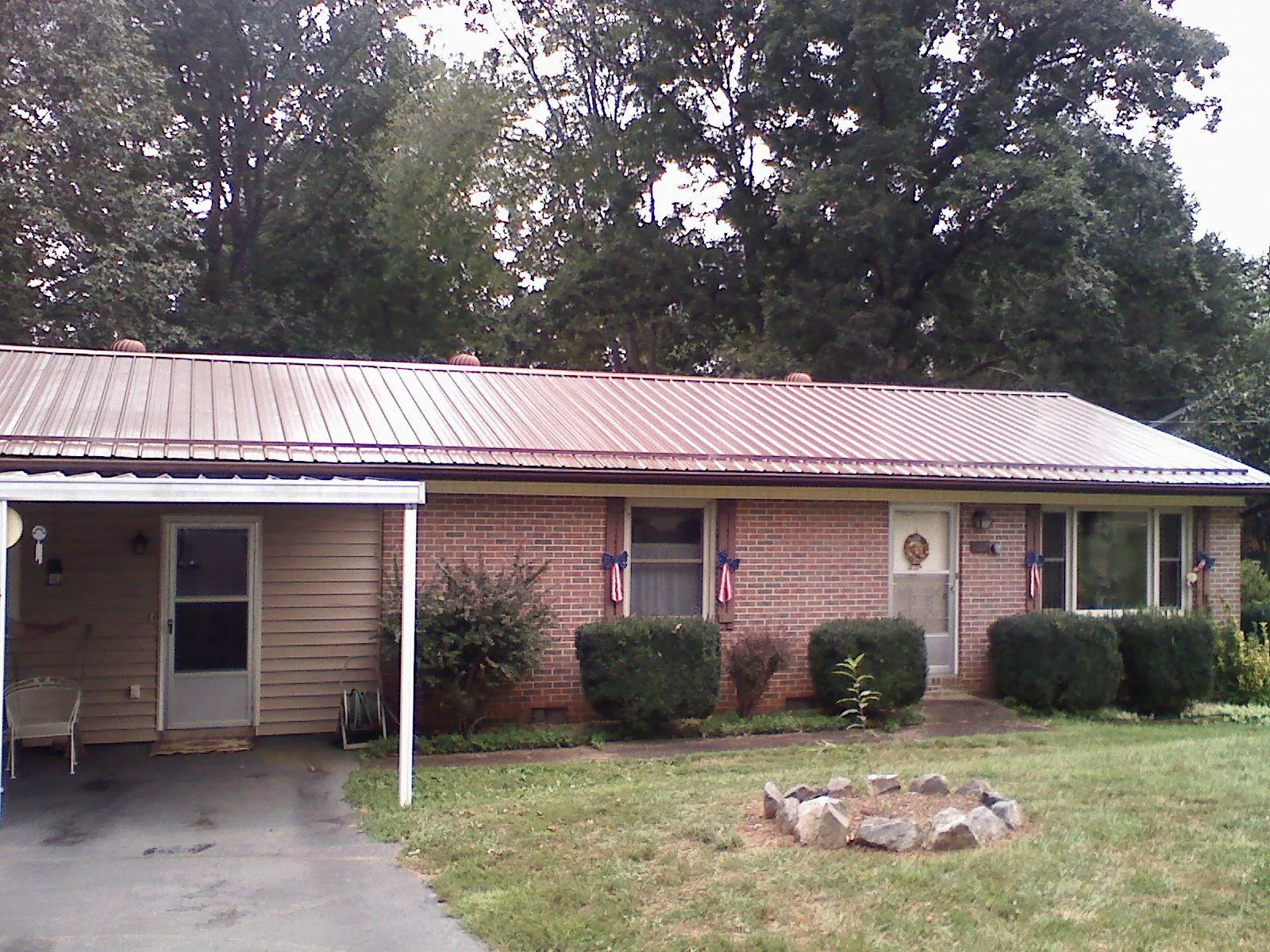 Bronze metal roof and carport on a brick ranch home — Roof Repair work by our crew in Elberon